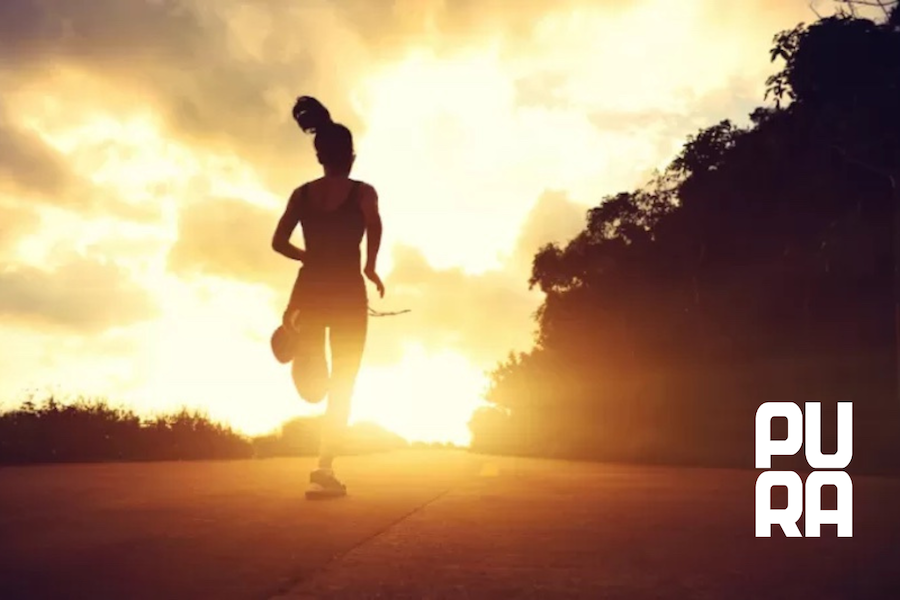 Mujer entrenando al aire libre al amanecer con actitud concentrada y equilibrada, representando disciplina inteligente y entrenamiento sostenible sin exceso.